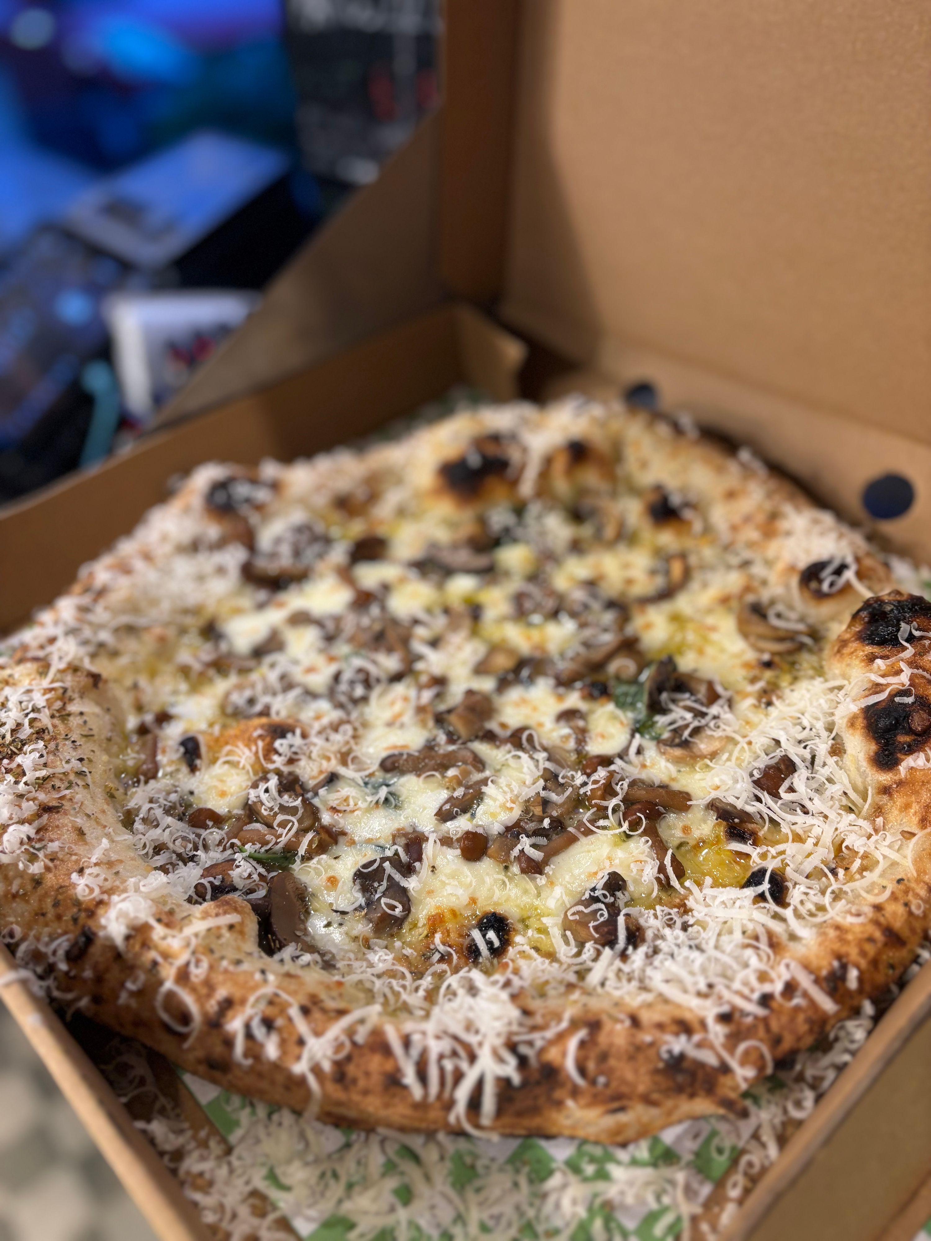Truffle della Notte - Pizza with truffle oil, parmesan, mozzarella, dried herbs, mixed mushrooms, fresh basil and a parmesan + herb crust.